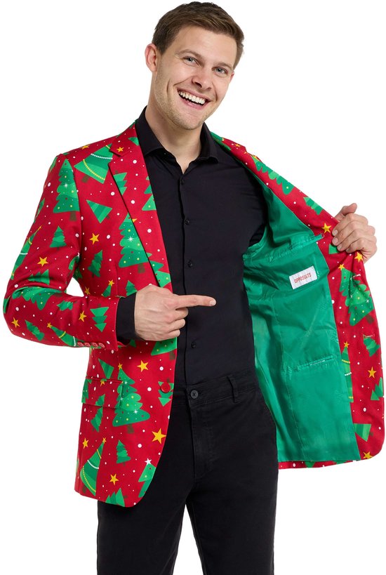 Man met kerstboomblazer in rood met groene bomen en sterren, toont de groene voering.