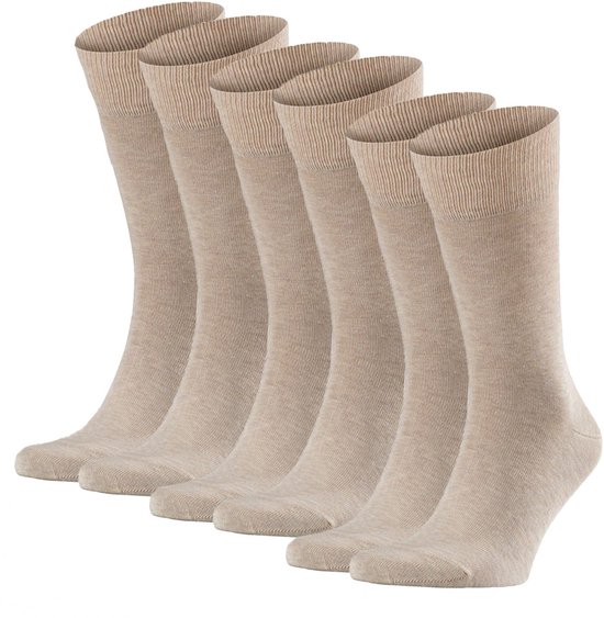 Zes beige Falke Happy sokken gerangschikt in een boog.