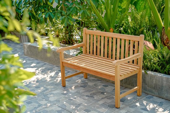 Houten tuinbank met gestreepte zitting, tussen weelderig groen.