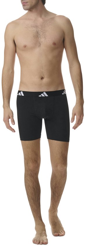 Model draagt zwarte adidas boxershort met witte logo-details op de tailleband.