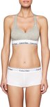 Model in grijze Calvin Klein bralette met V-hals en wit logo-elastiek.