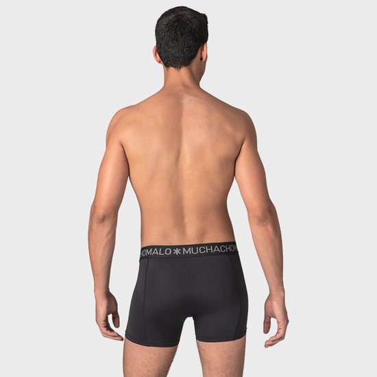 Achterkant van een man in een zwarte boxer met grijze merklogo tailleband.