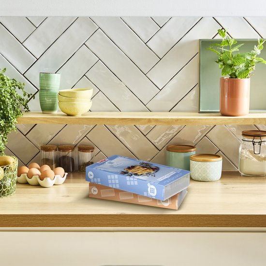Twee dozen van Tefal 'Snack Collection' met afbeeldingen van wafels en broodjes, staan op een houten plank.