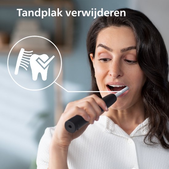 Vrouw met donker haar poetst tanden met een zwarte sonische tandenborstel en toont een tandplakverwijderingsicoon.