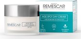 Witte pot Remescar Age Spot Day Cream SPF 50 en verpakking. De crème vermindert ouderdomsvlekken en herstelt de huid.