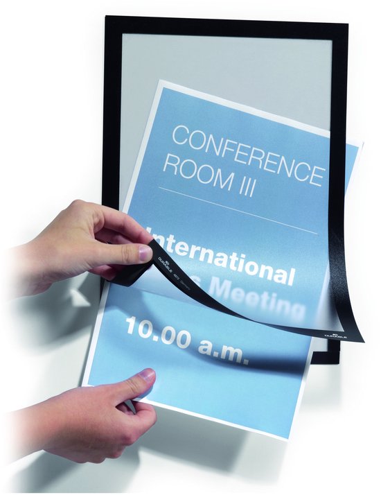 Twee handen bevestigen een poster met de tekst 'CONFERENCE ROOM III' in een zwart frame.