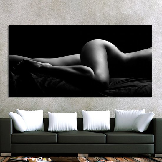 Peinture sur toile noir et blanc d'une femme allongée sur le ventre, vue de côté. La peinture est accrochée au-dessus d'un canapé noir.