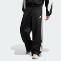 Zwarte trainingsbroek met wijde pijpen en beige 3-strepen, met adidas logo.