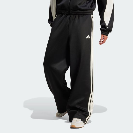 Zwarte trainingsbroek met wijde pijpen en beige 3-strepen, met adidas logo.