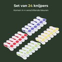 Een set van 24 wasknijpers in vier verschillende kleuren: paars, rood, geel en groen.