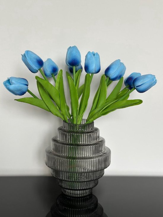 Boeket lichtblauwe tulpen in een grijze vaas met ribbels.