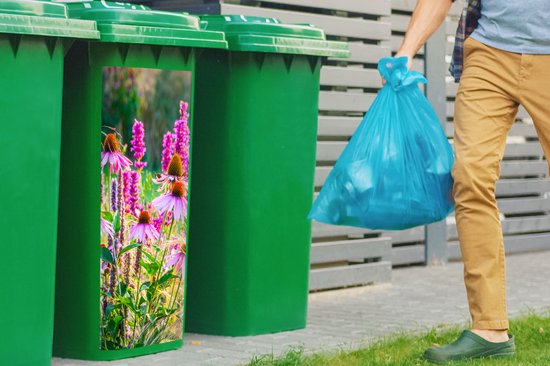 Groene afvalcontainers met sticker van roze echinacea en siergras, met een man die een blauwe vuilniszak draagt.
