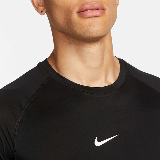 Close-up van een man met zwarte Nike Pro top met korte mouwen en zilveren Nike logo.