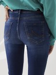 Close-up van de achterkant van een donkerblauwe flared jeans met stiksels op de achterzakken.