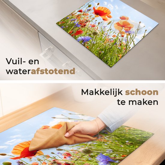 Afbeelding toont een close-up van rode klaprozen en blauwe bloemen op een zonnige dag. Een hand veegt de plaat schoon met een doek.