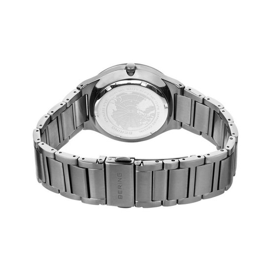 Achterkant van een zilverkleurig Bering horloge met gesp.