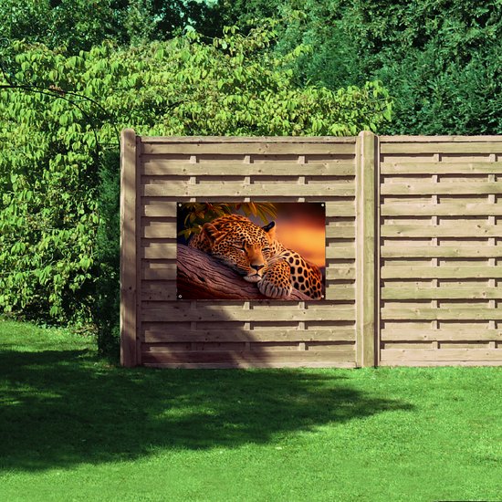 Een tuinposter met een slapend luipaard op een boomstronk, bevestigd aan een houten schutting in een tuin.