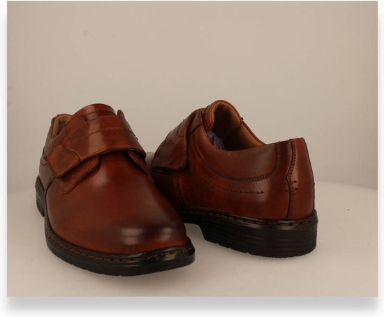 Paar cognac leren schoenen, van achteren gezien, met klittenbandsluiting en gestikte details.
