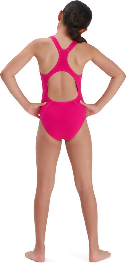 Meisje in een felroze Speedo sportbadpak, van achteren gezien, met de handen in de zij.