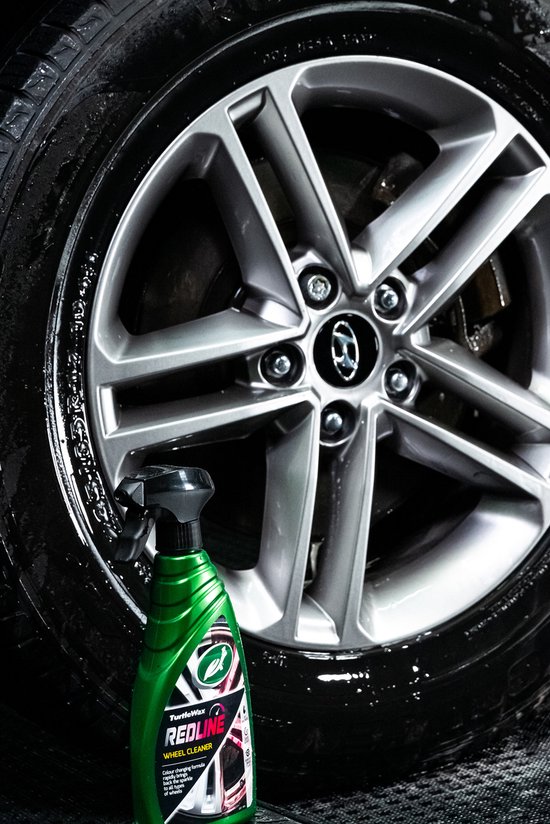 Une bouteille verte de Turtle Wax Redline à côté d'une roue propre.