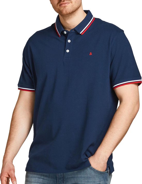 Man met donkerblauwe polo met rode en witte strepen op kraag en mouwen. Rode '&' opdruk.