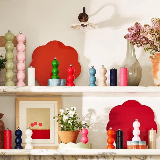 Verschillende miniatuur peper- en zoutmolens in pastelkleuren, waaronder roze, lichtgroen, lichtblauw en cappuccino, op een marmeren plank.
