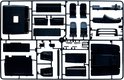 Zwarte spuitgietonderdelen voor een modelbouw vrachtwagen, inclusief stoelen en cabine-interieur.