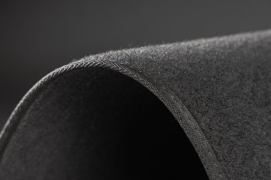 Détail du bord courbé d'un tapis de voiture gris foncé texturé.