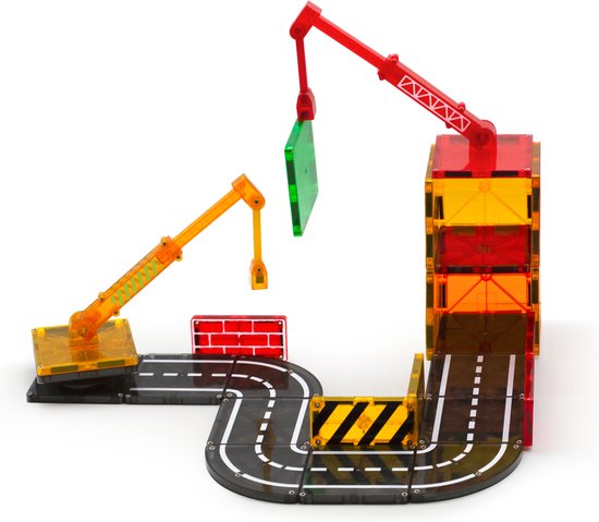 Een constructie van Magna-Tiles met twee hijskranen, wegen, bakstenen en transparante blokken in rood, geel, groen en grijs.