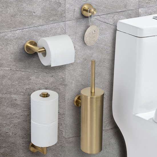 Gouden geborsteld RVS toiletaccessoireset aan een grijze tegelmuur: toiletrolhouder, toiletborstelhouder, handdoekhaakje en reserverolhouder naast een toilet.