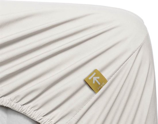 Crème hoeslaken met gele label 'k non-iron'.