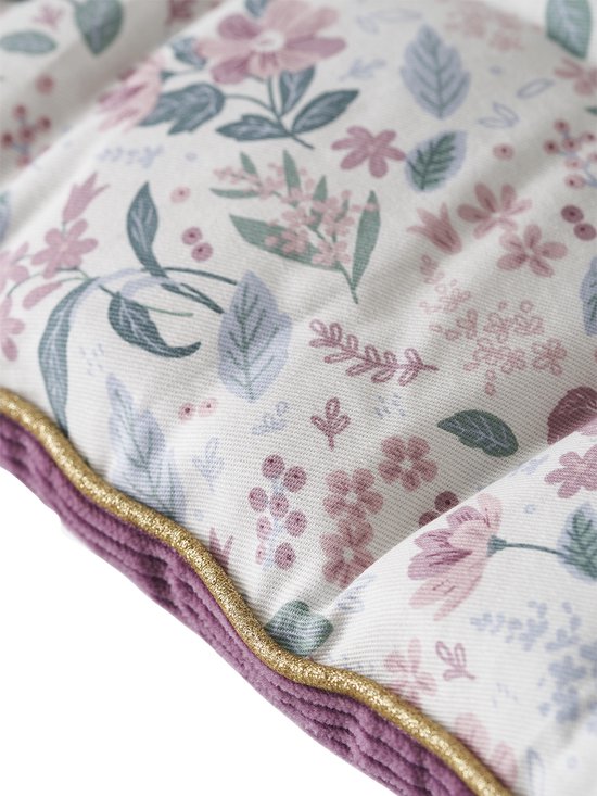 Detail van een wit vloermatras met een bloemenprint in roze, paars en blauw. Goudkleurig biesje en paarse ribstof rand.