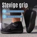 Zwarte Liromed schoen met klittenbandsluitingen, gedragen door een persoon. Schokabsorberende zool en verlichting van hielpijn.