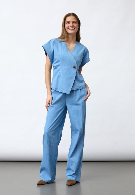 Mannequin portant un haut portefeuille bleu clair à manches courtes et un pantalon assorti.