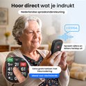 Oudere vrouw met een seniorentelefoon met grote, kleurgecodeerde knoppen. De telefoon spreekt cijfers uit.