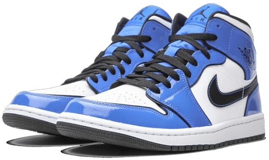 Vooraanzicht van een paar blauw-witte Air Jordan 1 Mid SE sneakers met zwarte veters en glanzende blauwe overlays.