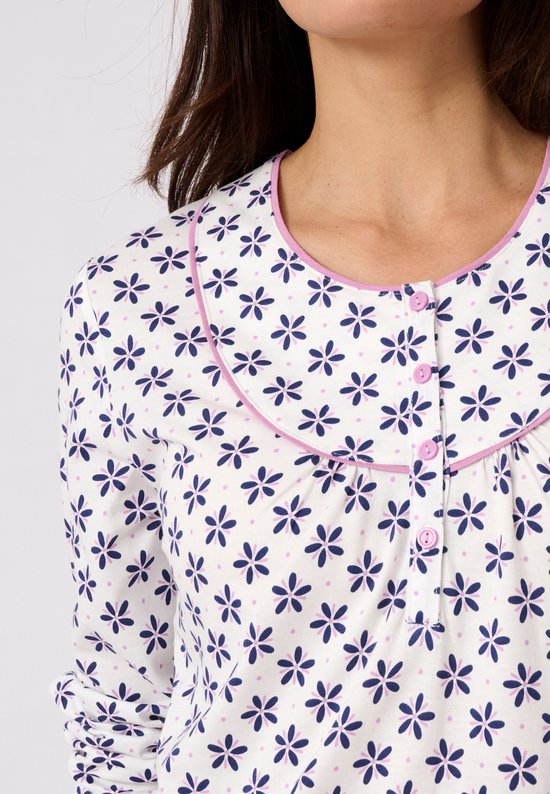 Detail van de neklijn van een wit nachthemd met lange mouwen, met blauwe bloemenprint, roze biezen en knoopjes