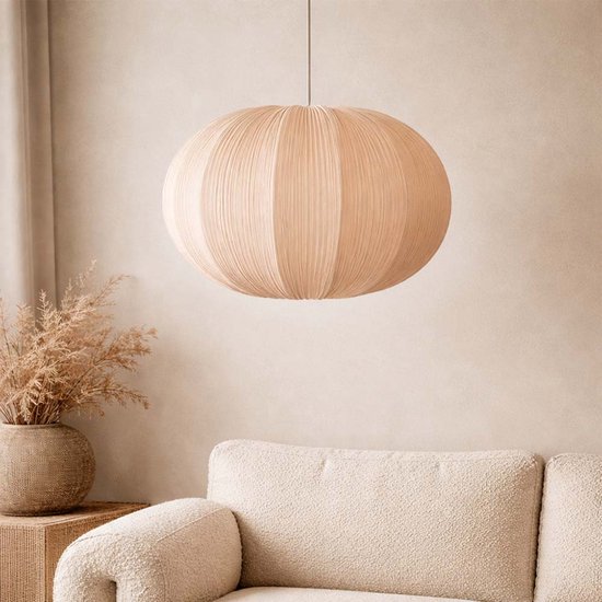 Beige, ronde hanglamp met verticale plooien in een woonkamer.