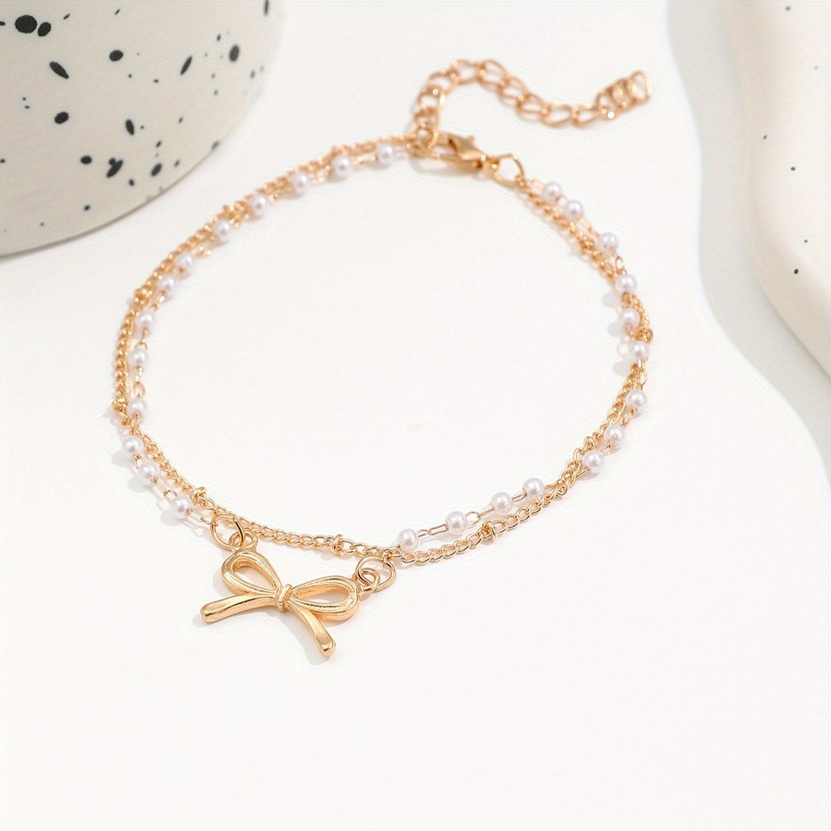 Sjika - Enkelbandje Dames Goudkleurig met Strik & Parels – Dubbele Enkelband – Trendy Zomer Enkelketting – Boho Voetsieraad - Cadeau voor haar