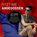 Een man met een t-shirt en zonnebril zit op een grote, donkerblauwe zitzak. Hij kijkt naar de zijkant.