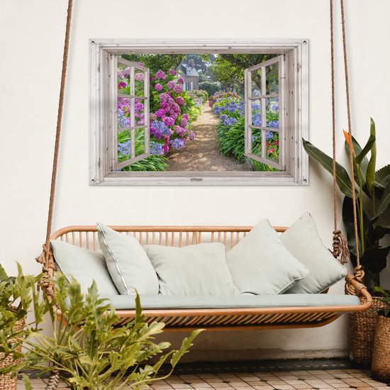Une fenêtre avec volets ouverts montre un chemin de jardin avec des fleurs roses et violettes.
