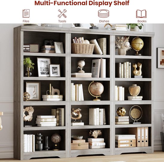 Grijze, modulaire open vakkenkast met 12 vakken, gevuld met boeken, decoraties, dossiers en schalen.