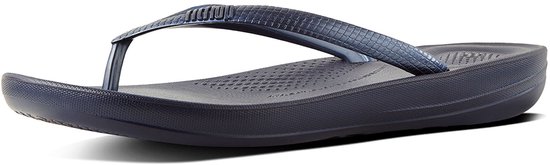 Donkerblauwe FitFlop teenslipper met een geweven bandje, van de zijkant gezien.