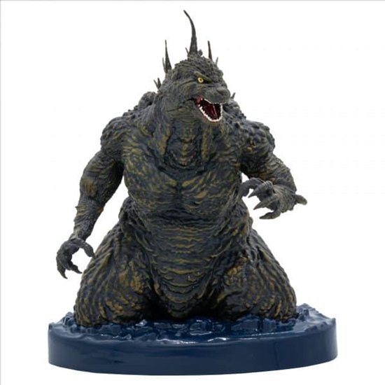 Grijze Godzilla figuur met gele ogen, knielend op een blauwe waterbasis.