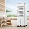 Witte mobiele airconditioner op wieltjes, met luchtstromen, naast een houten ligstoel in een lichte kamer.