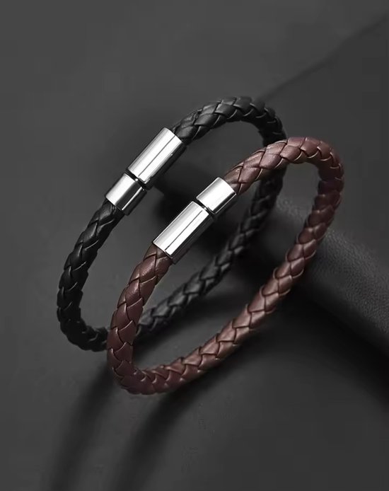 Twee gevlochten leren armbanden, zwart en bruin, met zilverkleurige magneetsluitingen.