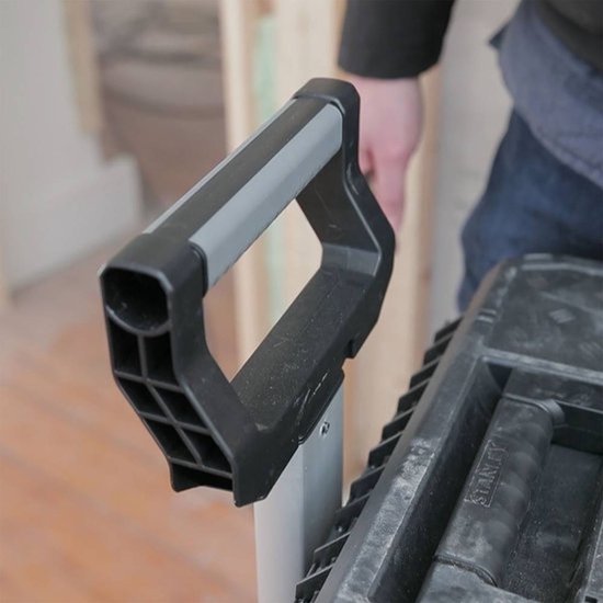 Zwarte kunststof handgreep met grijze accenten, op een gereedschapskoffer.