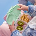 Lichtgroene bento box voor kinderen, gevuld met kiwi en krakelingen.