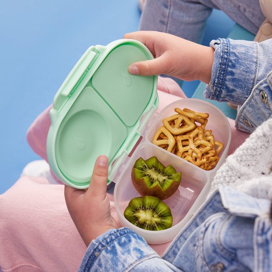 Lichtgroene bento box voor kinderen, gevuld met kiwi en krakelingen.