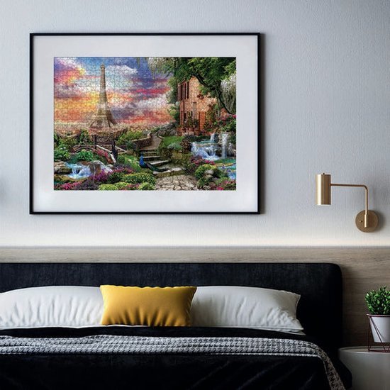 Een 3000-delige puzzel met "Droom van Parijs" is ingelijst en hangt boven een bed in een slaapkamer.